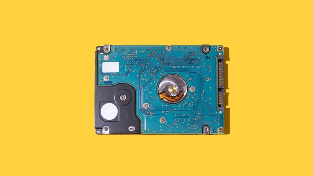 ATA SATA portable hard drive with the circuitry visible on a yellow background. Concept of computing, hardware, hard drive, storage, data, PC, assembly, technician and engineer.