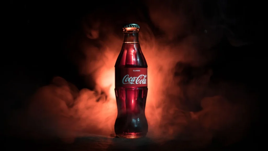 Baku, Azerbaijan 13th January 2018, Coca-Cola Classic in a glass bottle on dark toned foggy Background. Coca Cola is the most popular carbonated soft drink beverages sold around the world