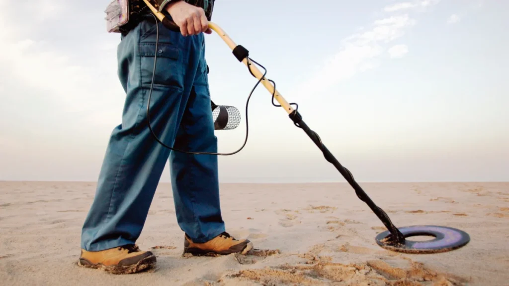 Man using metal detector at beach