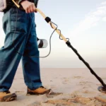 Man using metal detector at beach