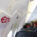 close up shot sign in airplane near emergency exit doors