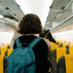 A young woman looking for her seat in the airplain