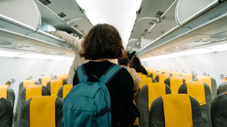 A young woman looking for her seat in the airplain