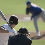 Pitcher throwing pitch to batter, catcher and umpire in foreground