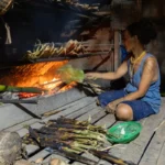 Mentawai woman cooking in the kitchen in the traditional house in the village on Siberut island West Sumatra Indonesia